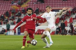 Mohamed Salah pelea por el balón con Toni Kroos.